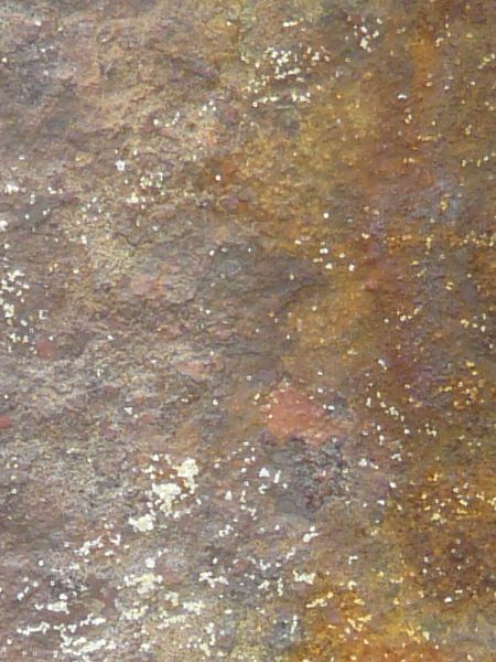 Rusted metal texture, formed into a rough, uneven surface in various hues of blue, yellow and red.